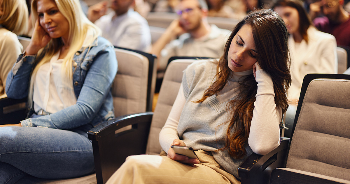 female spectator is bored with the event and looks at her phone